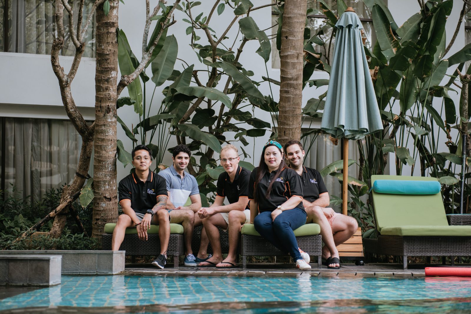 Team members sitting poolside at a retreat